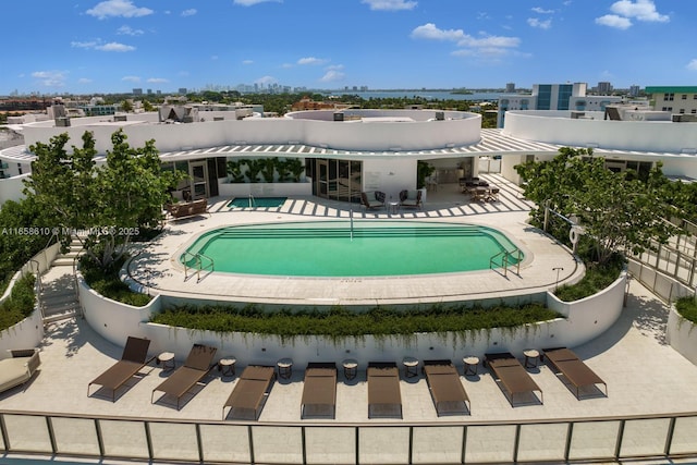 rear view of house with a community pool and a patio