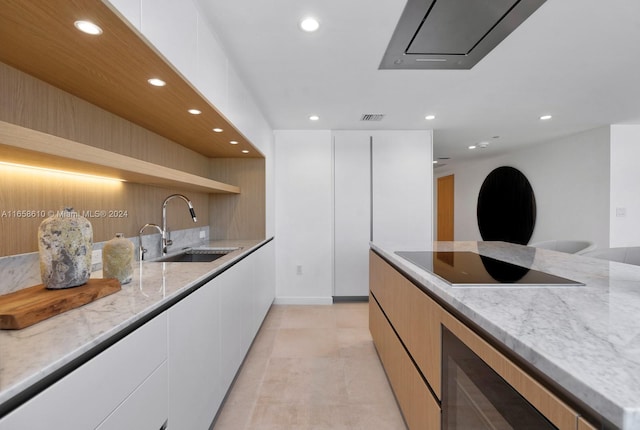 kitchen featuring white cabinets, sink, beverage cooler, black electric cooktop, and light stone countertops