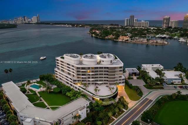 aerial view at dusk featuring a water view