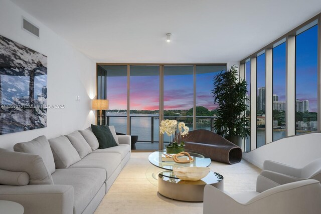 living room with a water view and a wall of windows