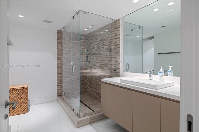 bathroom with tile patterned flooring, vanity, and a shower with shower door