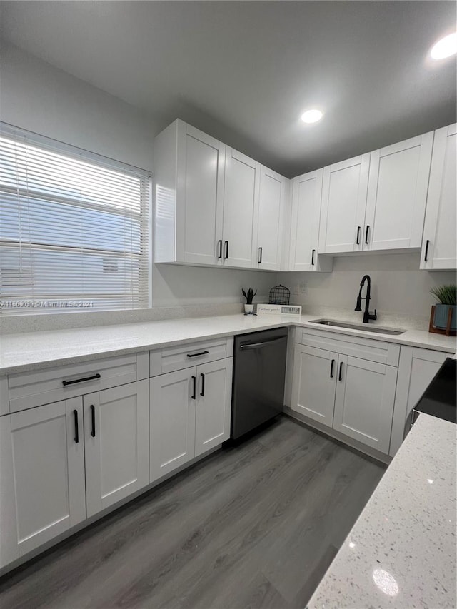 kitchen featuring stainless steel dishwasher, sink, and white cabinets