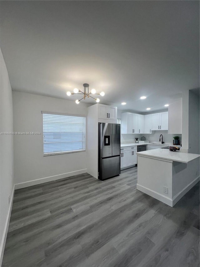 kitchen with kitchen peninsula, white cabinets, hardwood / wood-style flooring, an inviting chandelier, and stainless steel refrigerator with ice dispenser