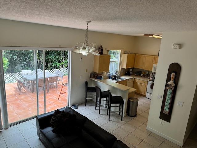 interior space with hanging light fixtures, a breakfast bar, kitchen peninsula, light brown cabinets, and an inviting chandelier