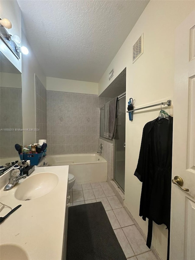 full bathroom featuring vanity, a textured ceiling, plus walk in shower, tile patterned floors, and toilet