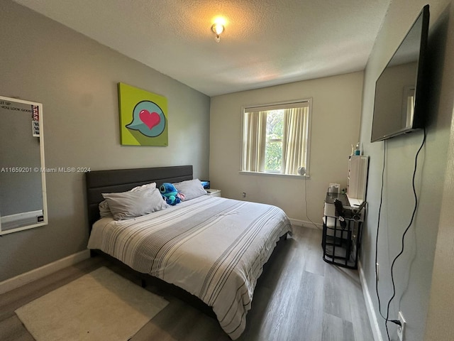 bedroom with a textured ceiling and hardwood / wood-style floors