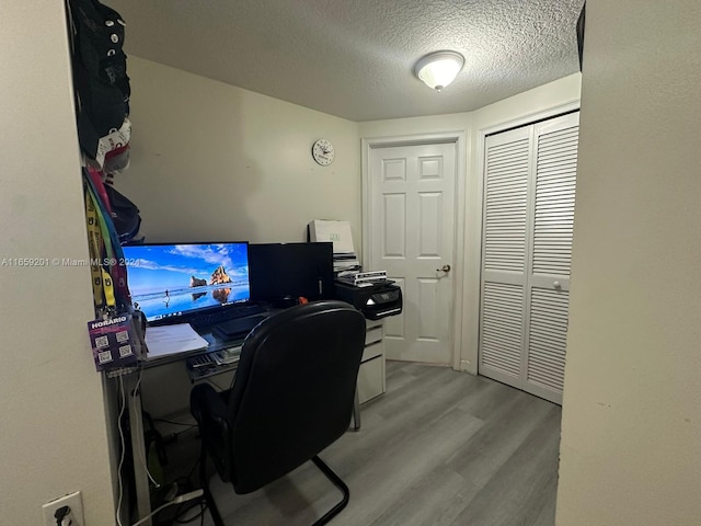 office with a textured ceiling and light hardwood / wood-style floors