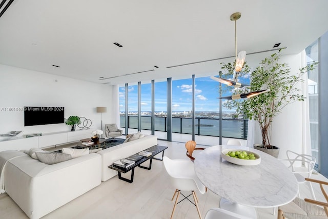 living room featuring floor to ceiling windows, a water view, and a wealth of natural light