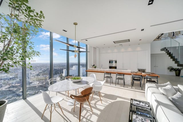 dining space featuring floor to ceiling windows and light hardwood / wood-style floors