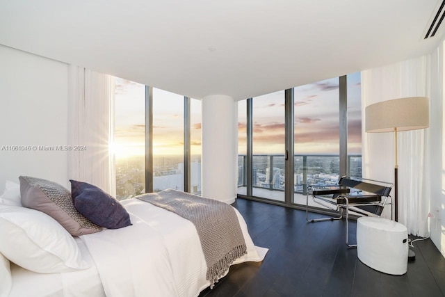 bedroom with expansive windows, dark hardwood / wood-style floors, and multiple windows