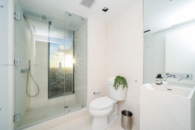 bathroom featuring tile patterned flooring, toilet, and a shower with door