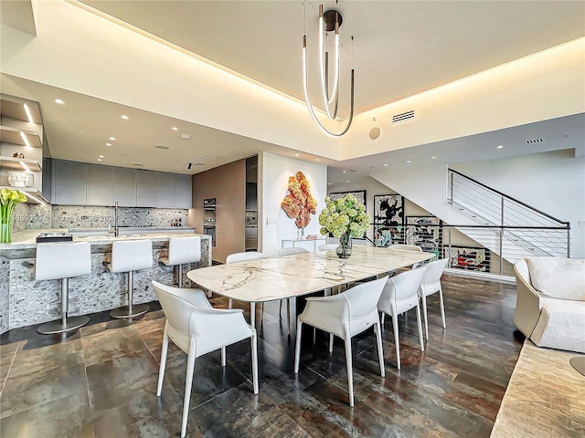 dining space with a towering ceiling and a chandelier