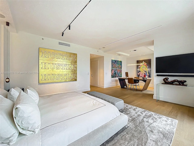 bedroom featuring wood-type flooring and rail lighting