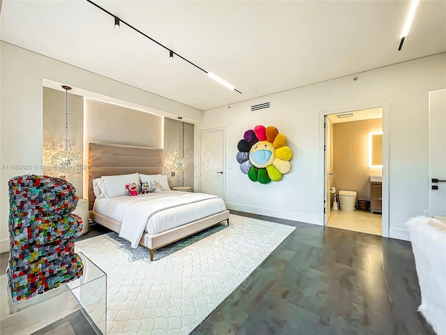 bedroom with ensuite bathroom and concrete floors