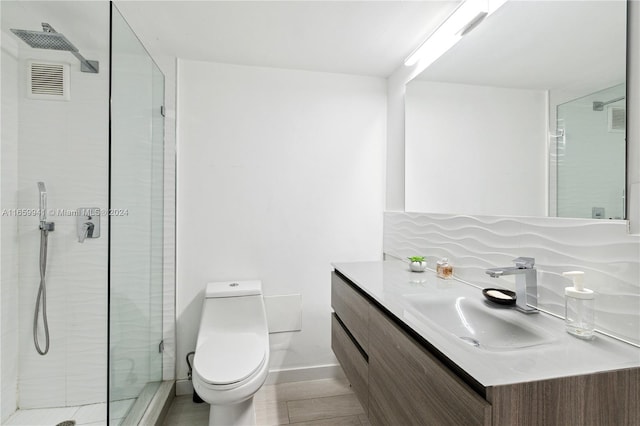 bathroom with a shower with door, vanity, and toilet