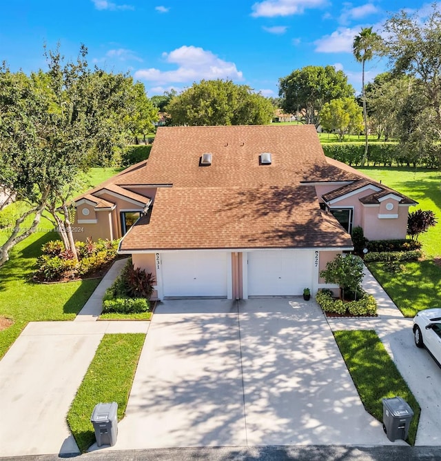 view of front of property featuring a garage and a front lawn