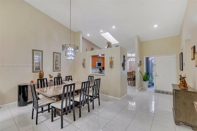 tiled dining room featuring a skylight, a notable chandelier, and high vaulted ceiling