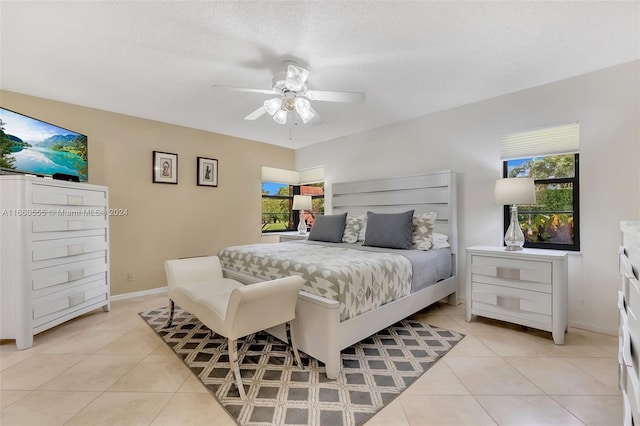 bedroom with ceiling fan, a textured ceiling, and light tile patterned floors