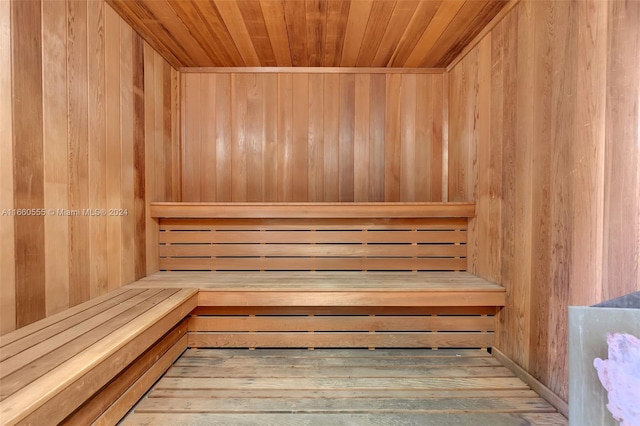 view of sauna with wood ceiling, wood-type flooring, and wooden walls