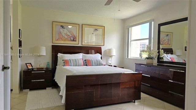 bedroom featuring ceiling fan, a textured ceiling, and light tile patterned floors