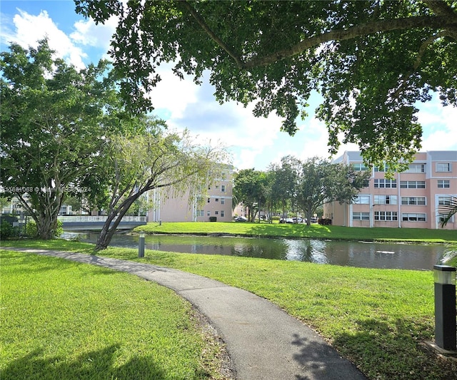 view of property's community featuring a lawn and a water view