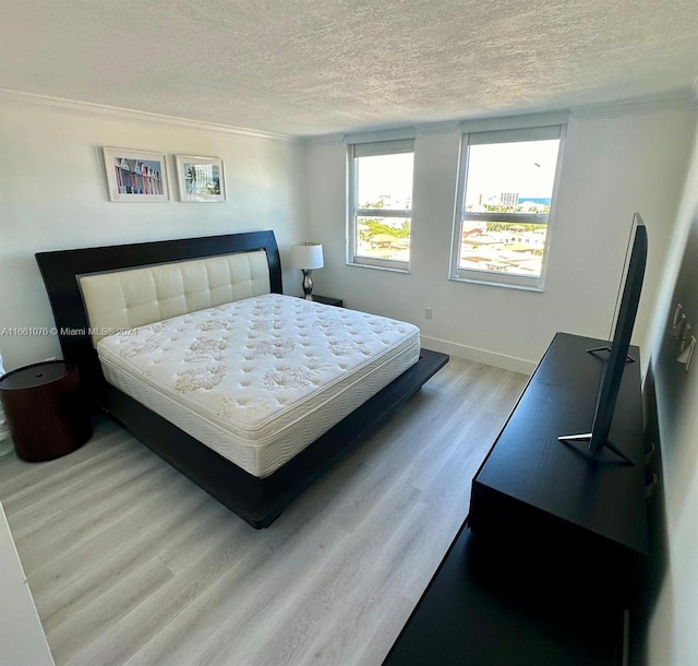 bedroom featuring light wood-type flooring and a textured ceiling