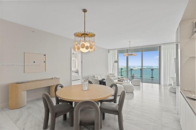 dining area with floor to ceiling windows, a chandelier, and a water view