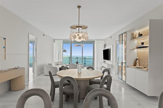 dining space with an inviting chandelier and a wall of windows