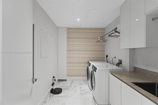 laundry area featuring cabinets, sink, and washing machine and dryer