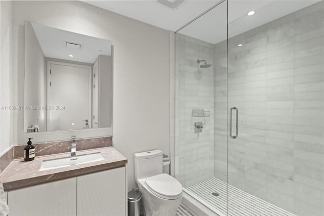 bathroom featuring vanity, toilet, and a shower with door