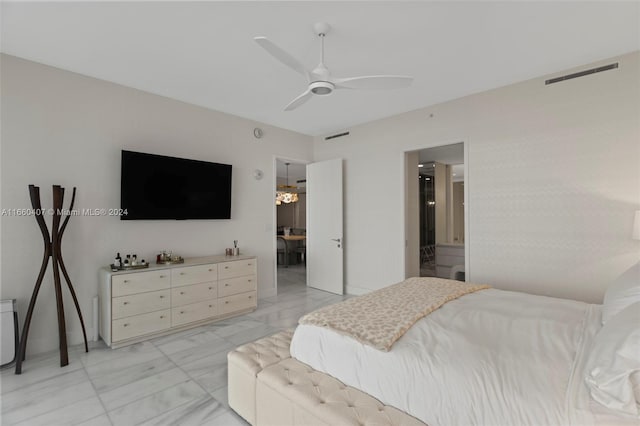 bedroom featuring ceiling fan with notable chandelier and ensuite bath