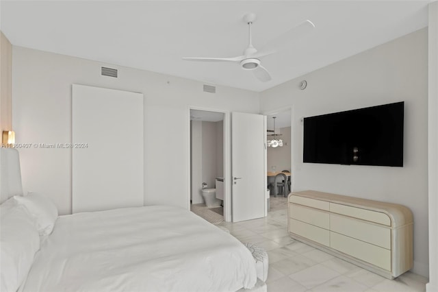 bedroom with ceiling fan with notable chandelier, ensuite bath, and a closet