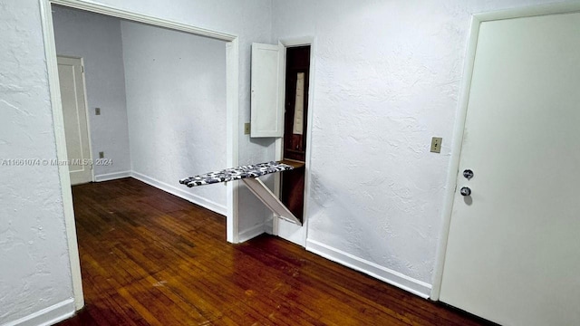 spare room featuring baseboards and wood finished floors