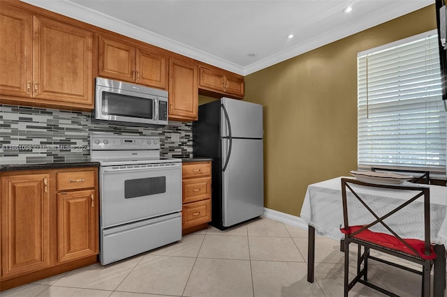 kitchen featuring crown molding, light tile patterned floors, stainless steel appliances, and plenty of natural light