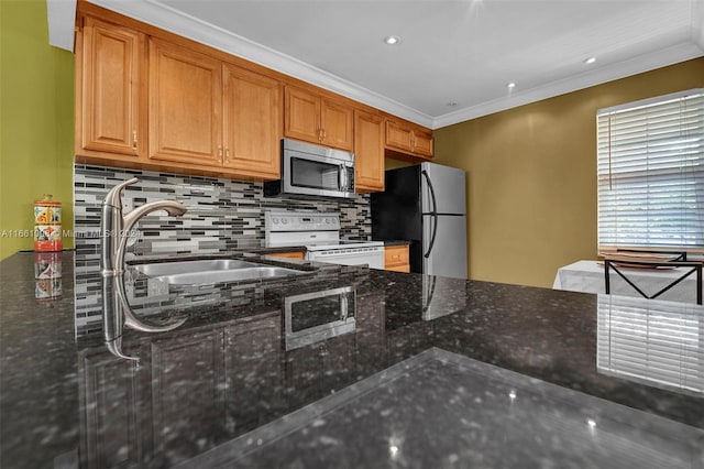 kitchen featuring ornamental molding, sink, appliances with stainless steel finishes, dark stone countertops, and decorative backsplash