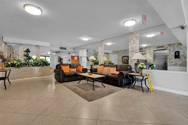 living room featuring a textured ceiling and light tile patterned floors