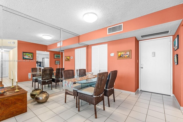 tiled dining room with a textured ceiling