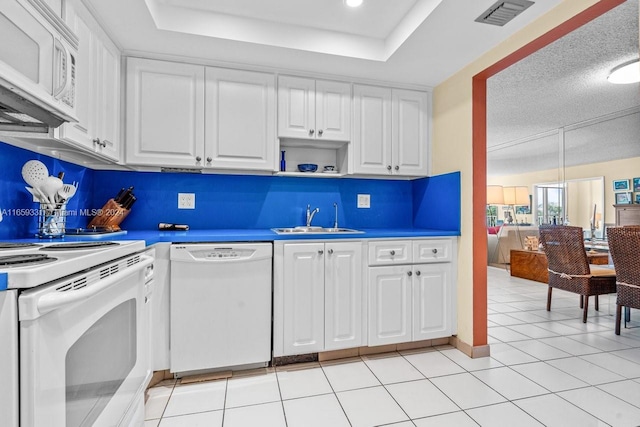 kitchen featuring sink, white appliances, a textured ceiling, backsplash, and white cabinetry