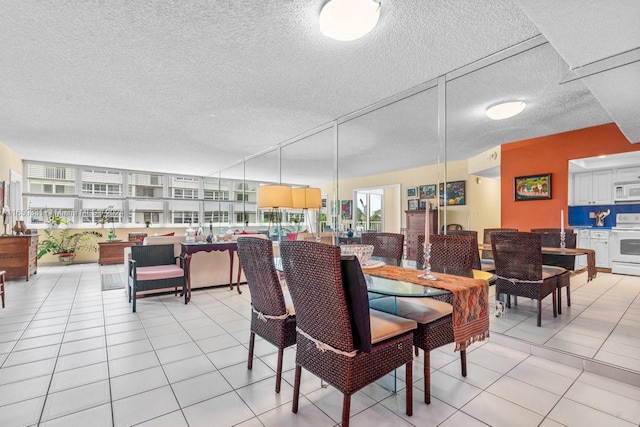 dining area featuring a textured ceiling and light tile patterned floors