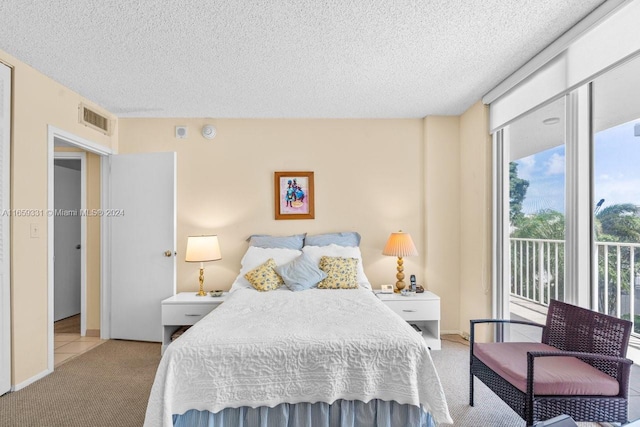 bedroom with light carpet, a textured ceiling, and access to outside