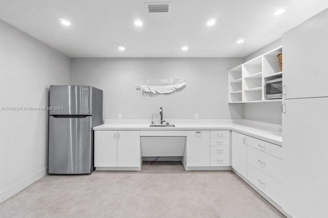 kitchen with white cabinets, appliances with stainless steel finishes, and sink