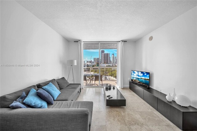 living room featuring a textured ceiling and floor to ceiling windows