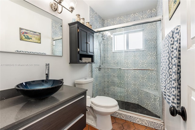 bathroom featuring tile patterned flooring, a shower with shower door, vanity, and toilet