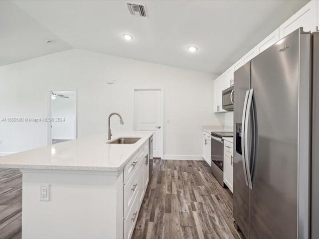 kitchen featuring a kitchen island with sink, sink, white cabinets, vaulted ceiling, and appliances with stainless steel finishes