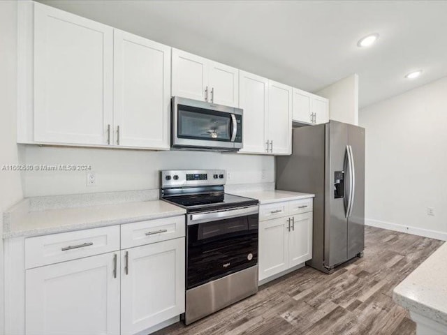 kitchen featuring appliances with stainless steel finishes, white cabinetry, and light hardwood / wood-style flooring