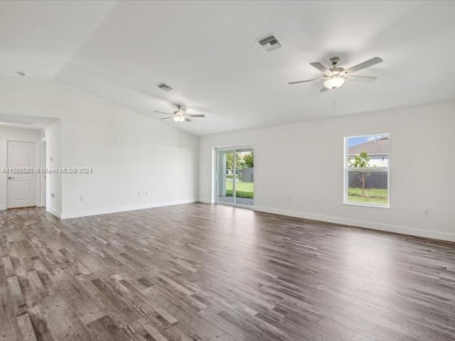 empty room featuring wood-type flooring, lofted ceiling, ceiling fan, and plenty of natural light