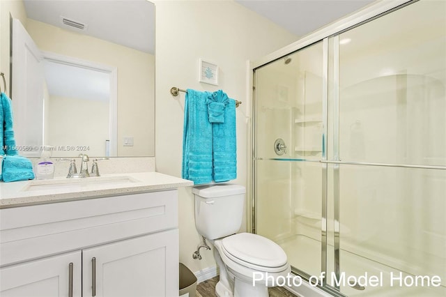 bathroom featuring vanity, toilet, and an enclosed shower