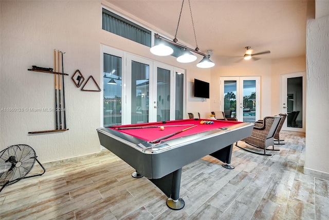 game room with pool table, light wood-type flooring, and french doors