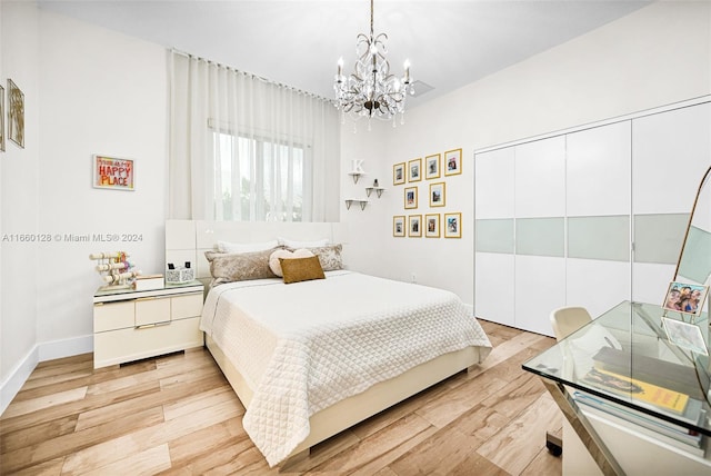 bedroom with light hardwood / wood-style floors, a chandelier, and a closet