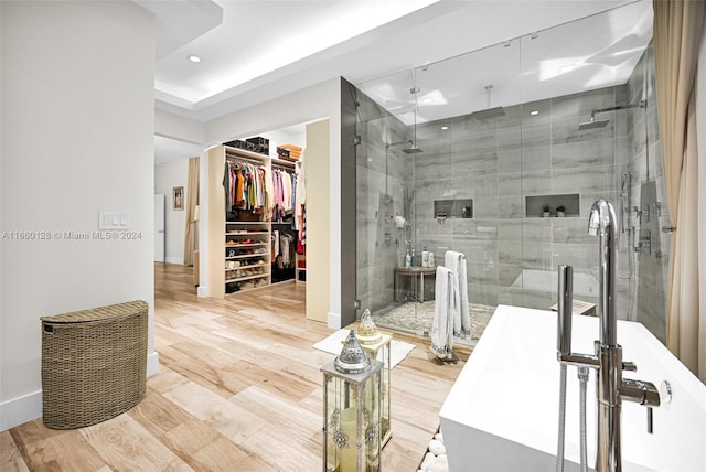 bathroom featuring shower with separate bathtub and hardwood / wood-style floors